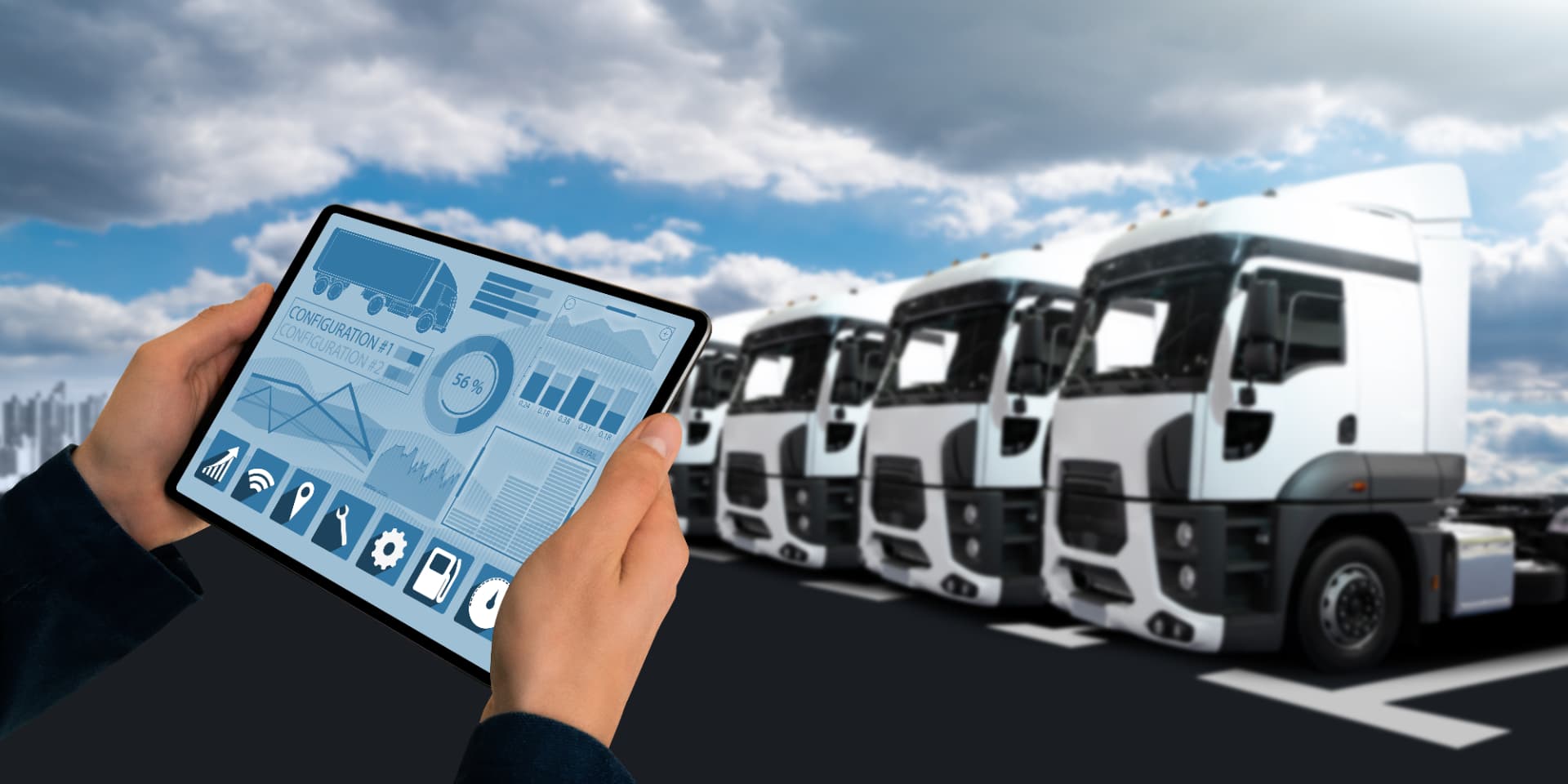 A dispatcher holding a tablet showing fleet metrics in front of a row of parked trucks